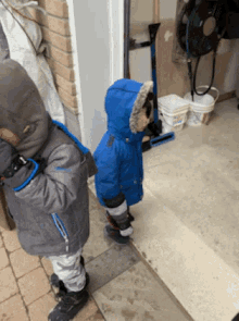 a boy in a blue jacket stands next to another boy in a gray jacket