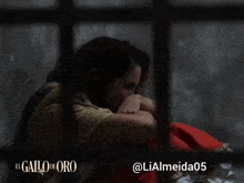 a woman sits in a prison cell with the hashtag @ lialmeida05