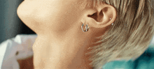 a close up of a person 's ear with earrings and piercings