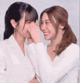 two women are looking at each other and smiling .