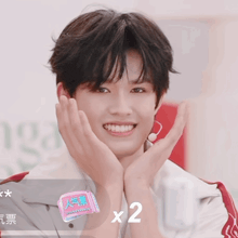 a young man with his hands on his face and a sticker that says x2 on it