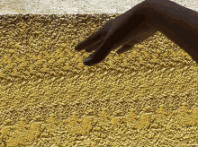 a person 's hand is pointing at a gold colored surface