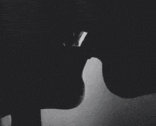 a black and white photo of a couple kissing .