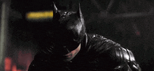 a close up of a man wearing a batman mask in the rain .