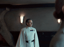 a man in a white uniform has a badge on his chest that says " commander "
