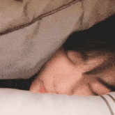 a close up of a person sleeping on a pillow