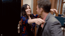 a man in a suit and a woman in a dress are hugging each other