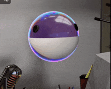 a purple and white ball floating in the air next to a microphone
