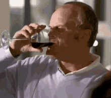 a man is drinking a glass of wine from a glass