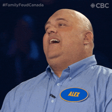 a man wearing a blue shirt with a name tag that says alex