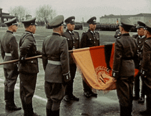 a group of men in military uniforms stand in a line