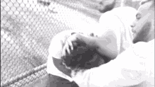 a black and white photo of two men hugging