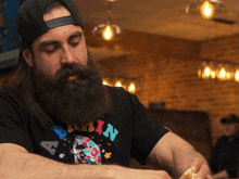 a man with a beard wears a shirt that says captain