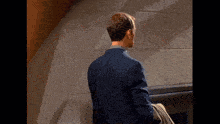 a man in a blue suit is looking at something