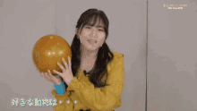 a girl in a yellow shirt is holding a bowling ball and says panda