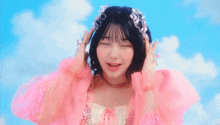 a young girl wearing a pink dress and a tiara