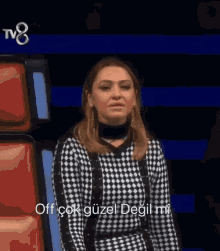 a woman wearing a black and white checkered dress says off çok güzel degil mi