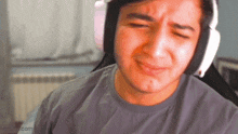 a man is wearing headphones and making a sad face