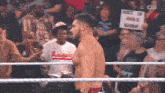 a man in a wrestling ring holds a sign that says next is a rivals show