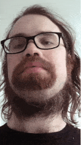 a man with glasses and a beard is wearing a black shirt with the number 1 on it