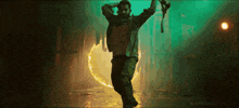 a man is dancing in a dark room with a green light behind him and the words nandamurifans.com at the bottom