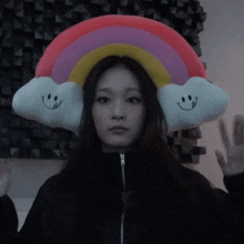 a woman wearing a hat with a rainbow and two smiling clouds