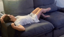 a woman is laying on a couch with her feet up and her legs crossed .