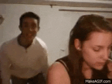 a man and woman are standing next to each other in a room .