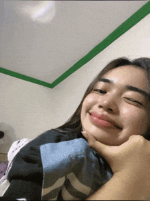 a woman laying on a bed with her eyes closed and her hand on her chin
