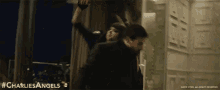 a man and a woman are fighting in a room with the hashtag charliesangels