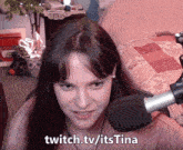 a woman sitting in front of a microphone with the words twitch.tv/itstina written on the bottom