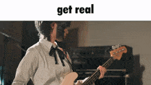 a woman is playing a bass guitar with the words get real behind her