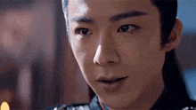 a close up of a young man 's face with his eyes closed and a smile on his face .