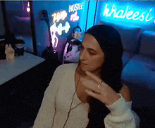 a woman wearing headphones is sitting in front of a sign that says khaleesi