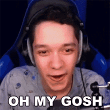 a man wearing headphones is sitting in front of a microphone and saying oh my gosh