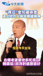 a man in a suit and tie is speaking into a microphone with chinese writing on it