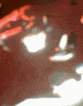 a blurred image of a person 's hands reaching out towards an apple