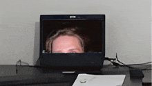 a woman 's face is visible on a laptop screen