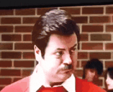 a man with a mustache is wearing a red sweater and white shirt .