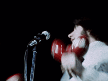 a man singing into a microphone while wearing a sweater