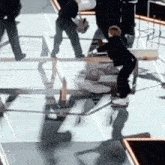 a group of people are standing around a table with a reflection of a person in the table