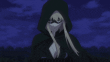 a woman in a hooded cape is holding a yellow object in her hand