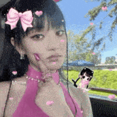 a girl with a pink bow on her head is making a peace sign with her hand .