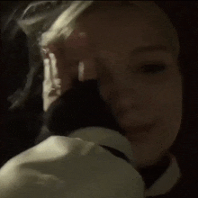 a woman covering her face with her hand in the dark