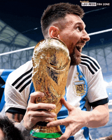 a soccer player holding a trophy that says leo messi fan zone