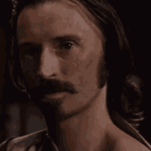 a man with long hair and a beard is without a shirt