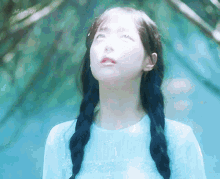 a girl with braids in her hair is wearing a blue shirt