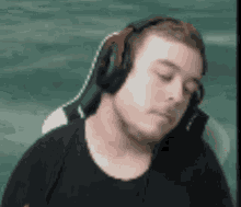 a man wearing headphones is sitting in a chair and making a funny face .