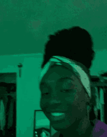 a woman wearing a headband is making a funny face with her eyes closed