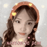 a close up of a girl wearing a headband with hearts on it .